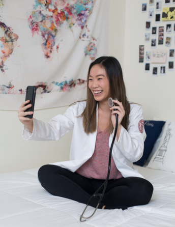  Natalie Nguyen ’23 shows off her stethoscope while video chatting with her boyfriend from her dorm room.